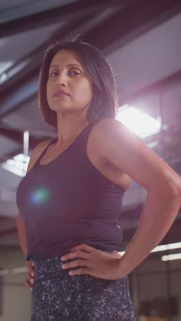 Vertical-Video-Portrait-Of-Mature-Woman-Wearing-Fitness-Clothing-Standing-In-Gym-Ready-To-Exercise